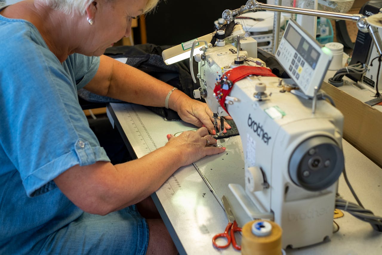 An elderly woman skillfully sewing in Harwich, England using a professional sewing machine.