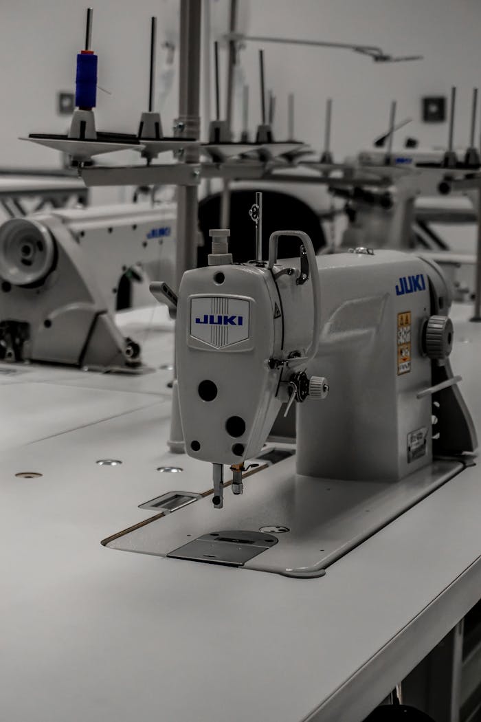 Close-up of an industrial sewing machine in a well-equipped textile workshop.